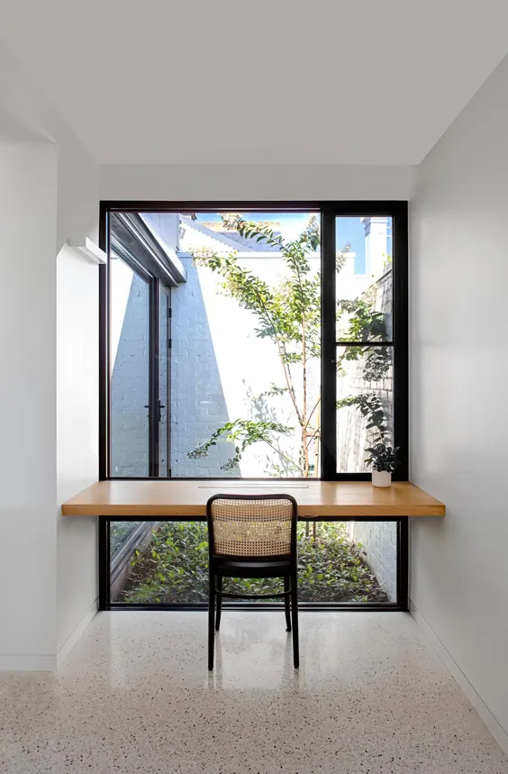 یک تخته چوب جلوی پنجره یک روش آسان برای ساخت یک میز برای یک دفتر کار خانگی است
