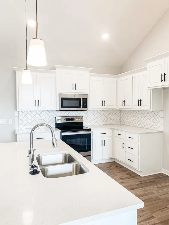 آشپزخانه سفید با کف های چوبی و چراغ های آویز - سازنده خانه کانزاس سیتی