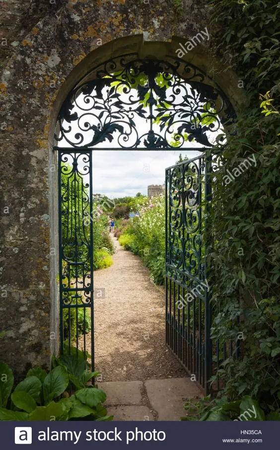 عکس - دروازه تزئینی آهن فرفورژه و ورودی طاق سنگی Cotswold به باغ دیواری خانه Rousham