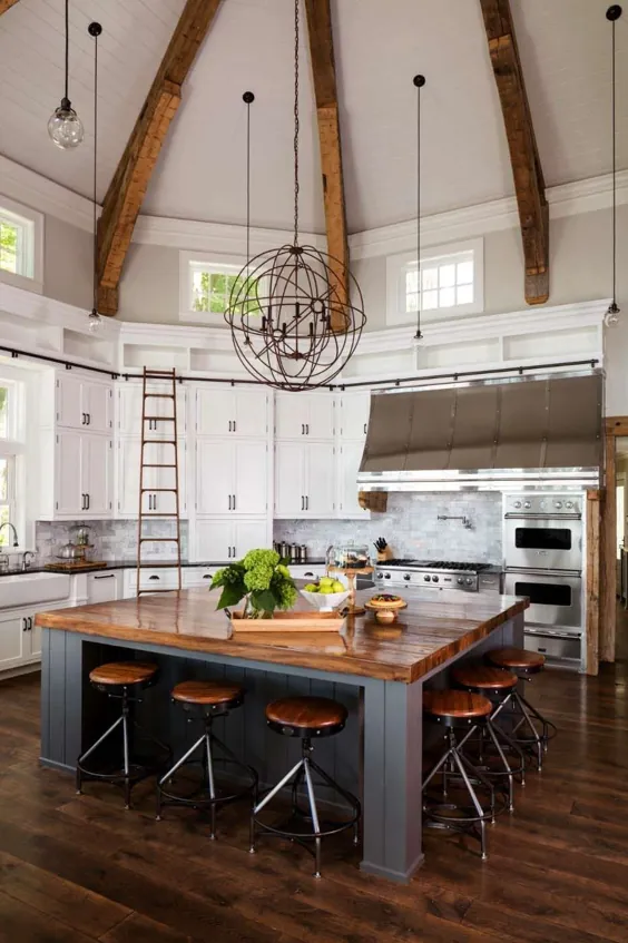 آشپزخانه اوپن با سقف طاقدار و یک جزیره بزرگ چوبی مرکزی در این خانه در دریاچه بزرگ سدر ، ویسکانسین.  [1400 9 932]