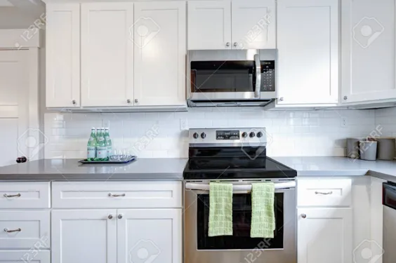 اتاق آشپزخانه سفید و خاکستری با لوازم مدرن از جنس استنلس استیل ، ..
