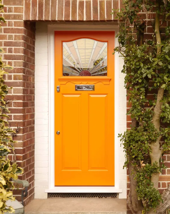 درب ورودی نارنجی با روکش سفید.  خانه آجر قرمز.  پانل شیشه رنگی.