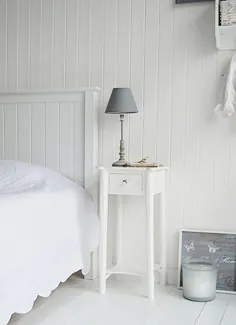 یک میز تخت خواب سفید و باریک با کشو و دسته نقره ای.  مبلمان اتاق خواب سفید نیو انگلند